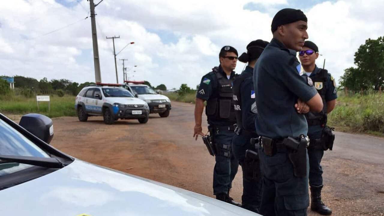 Brazil police officers stand guard outside a prison.