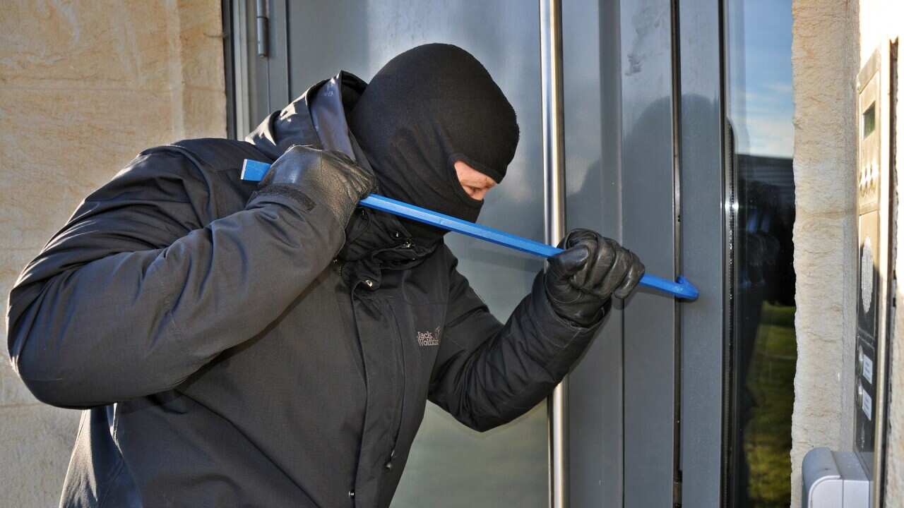 A burglar trying to get into a house.