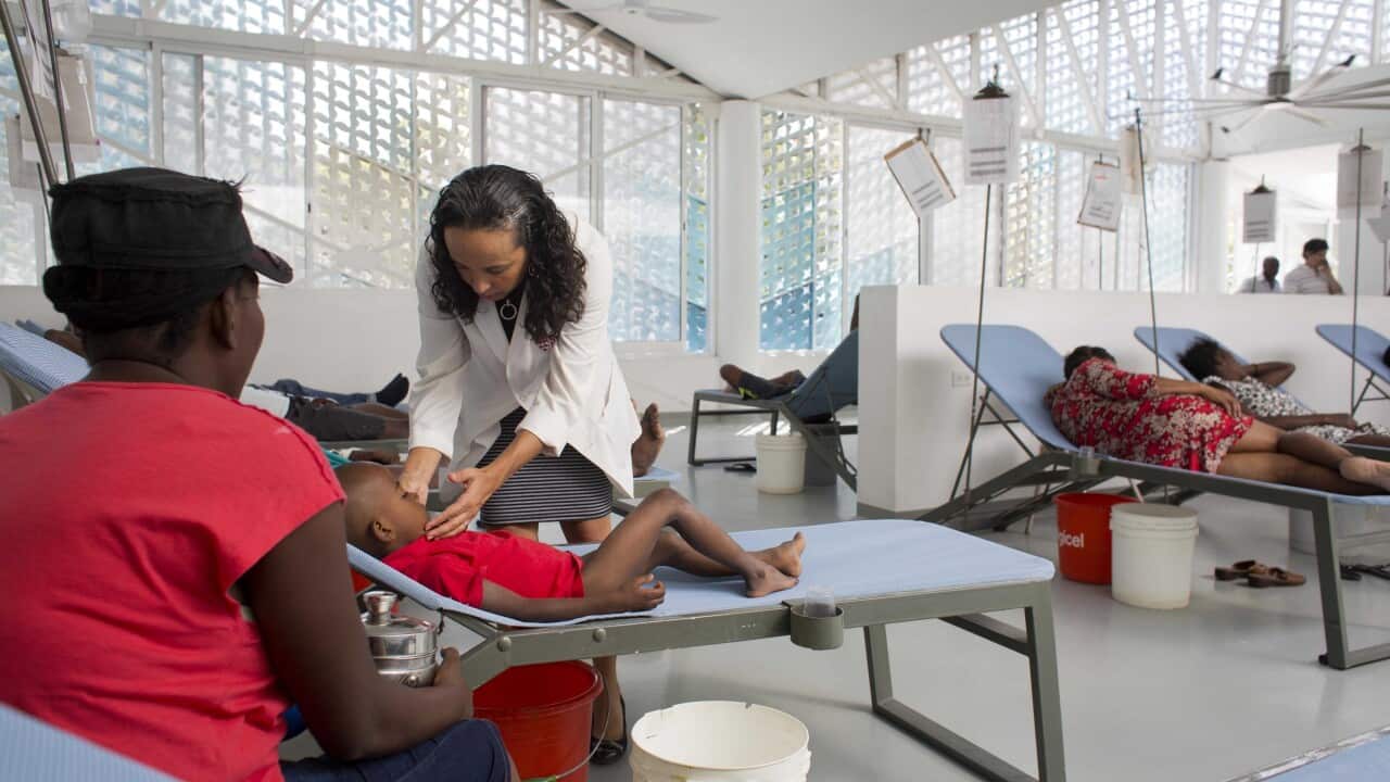 A doctor examines a child suffering from cholera symptoms in Haiti