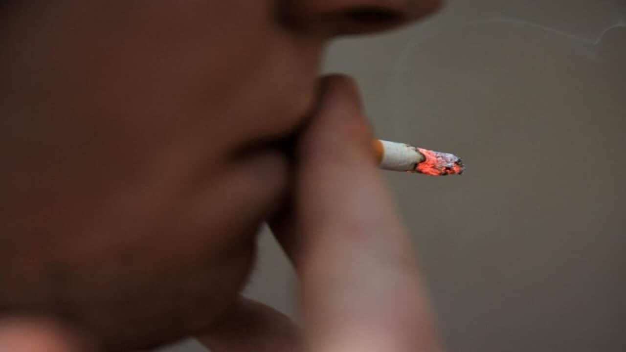 A man smoking a cigarette.
