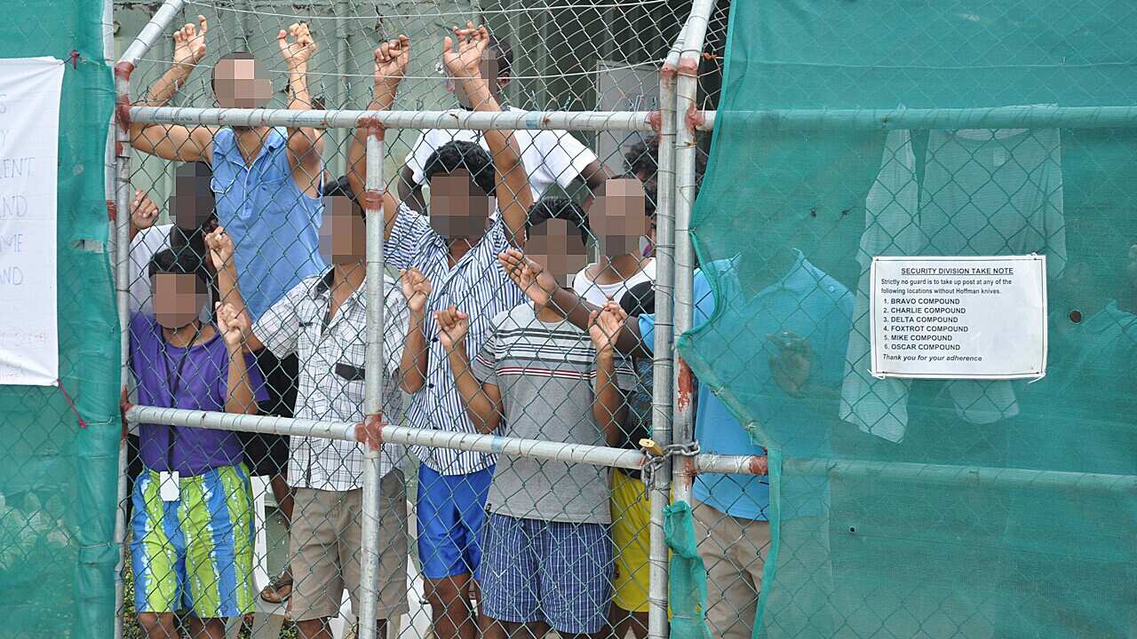 File image of asylum seekers behind a fence at the Manus Island detention centre, Papua New Guinea, March 2014.