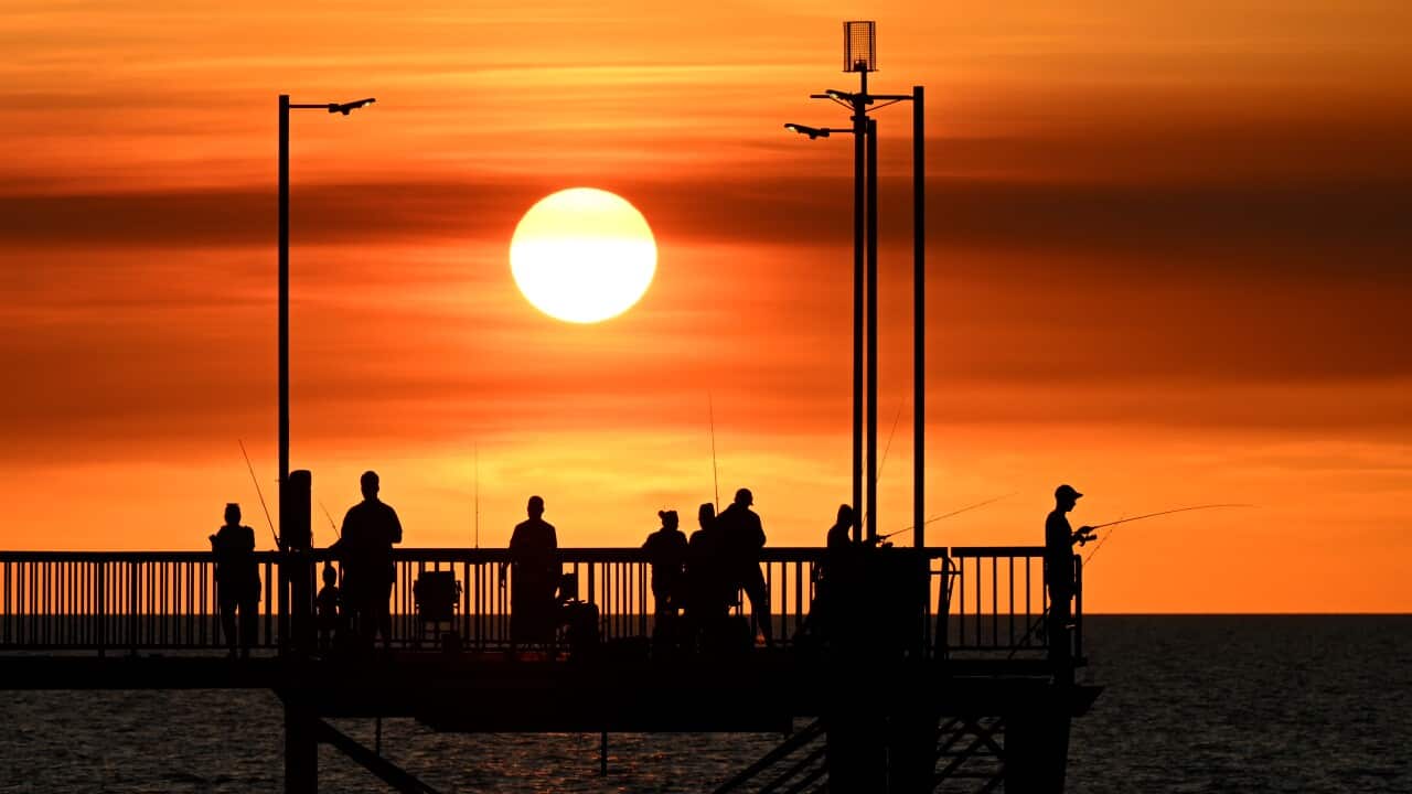 People are seen fishing on the Nightcliff Jetty as the sunsets in the suburb of Nightcliff in Darwin.