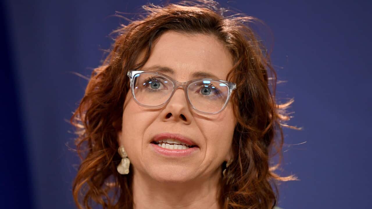 Woman wearing glasses speaking.