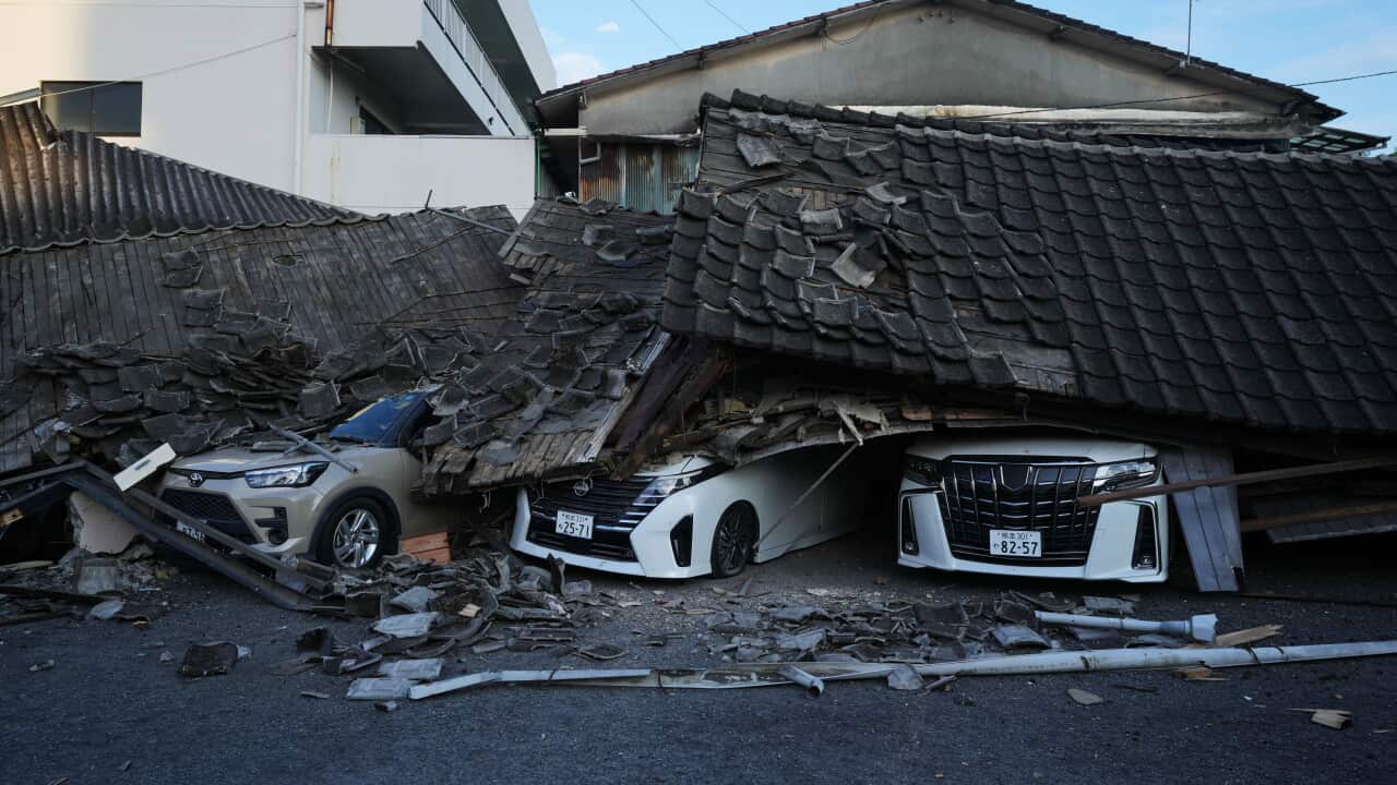 Three cars crushed underneath a collapsed roof.