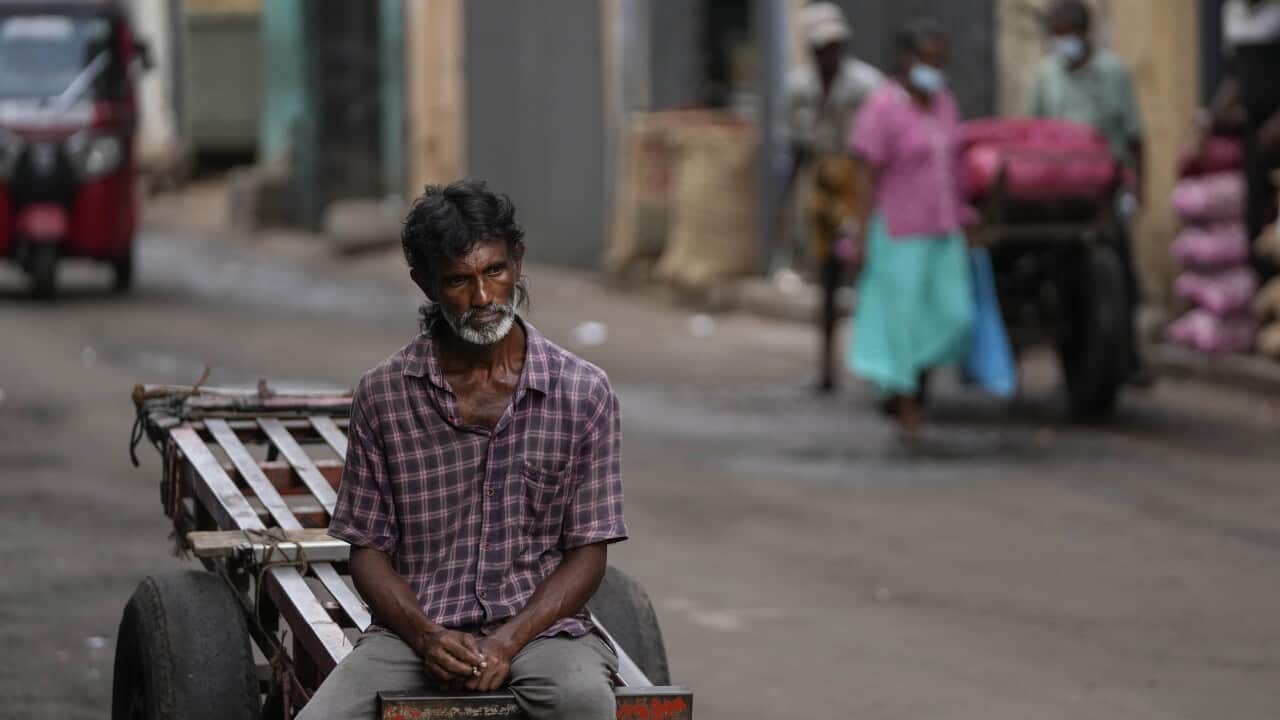 A man sits on a cartwheel looking dejected