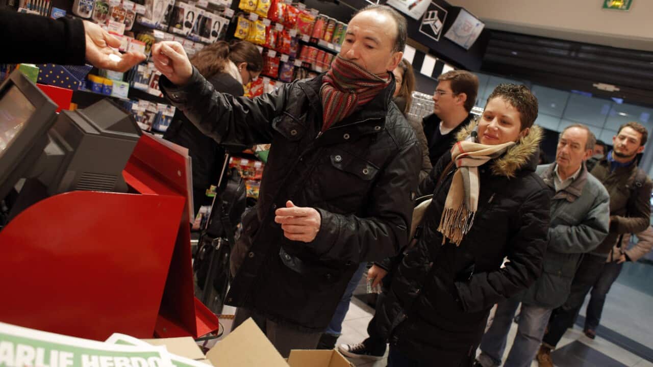 People queue up to buy the latest issue of Charlie Hebdo newspaper at a newsstand in Paris. (AP Photo/Christophe Ena)
