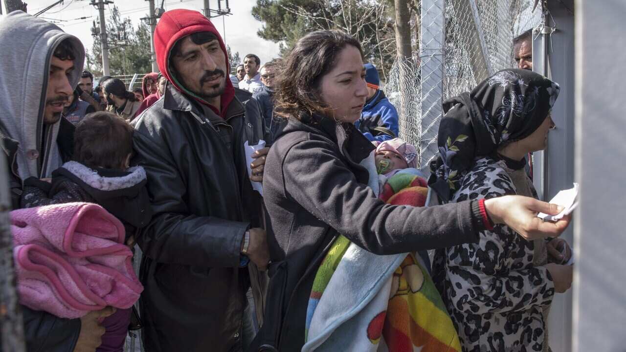 Refugees show their documents as they enter Macedonia near Gevgelija, The Former Yugoslav Republic of Macedonia, 02 March 2016.