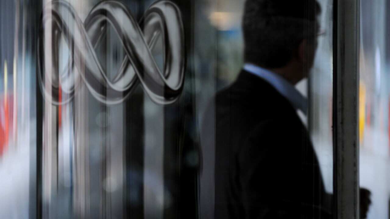 File photo of a man walking past an ABC logo