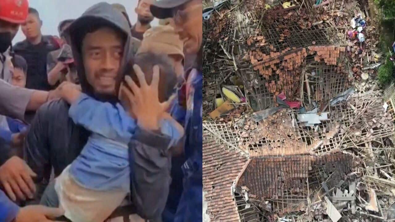 Five-year-old Azka being carried in the arms of a rescuer after being lifted from rubble in Indonesia.