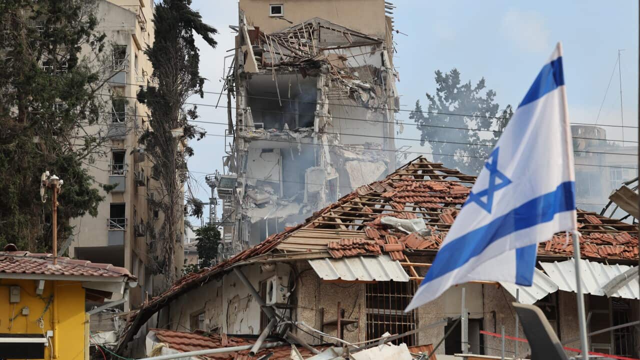 Israeli rescue teams work at the site of a damaged residential area after Iranian ballistic missiles hit Rehovot, central Israel