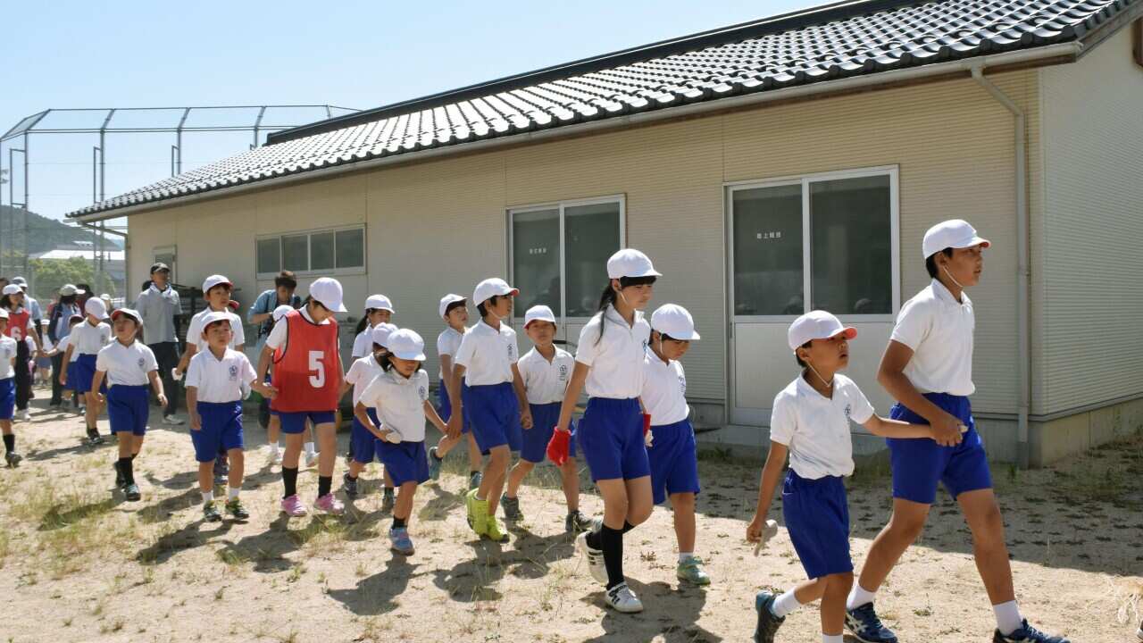 Schoolchildren leave the compound of their school during an evacuation drill in Abu town.