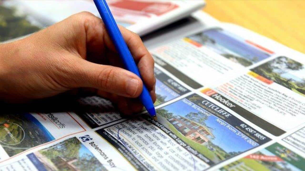 A person circles real estate advertising