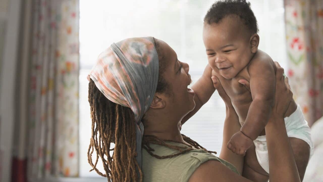 Black mother lifting baby son