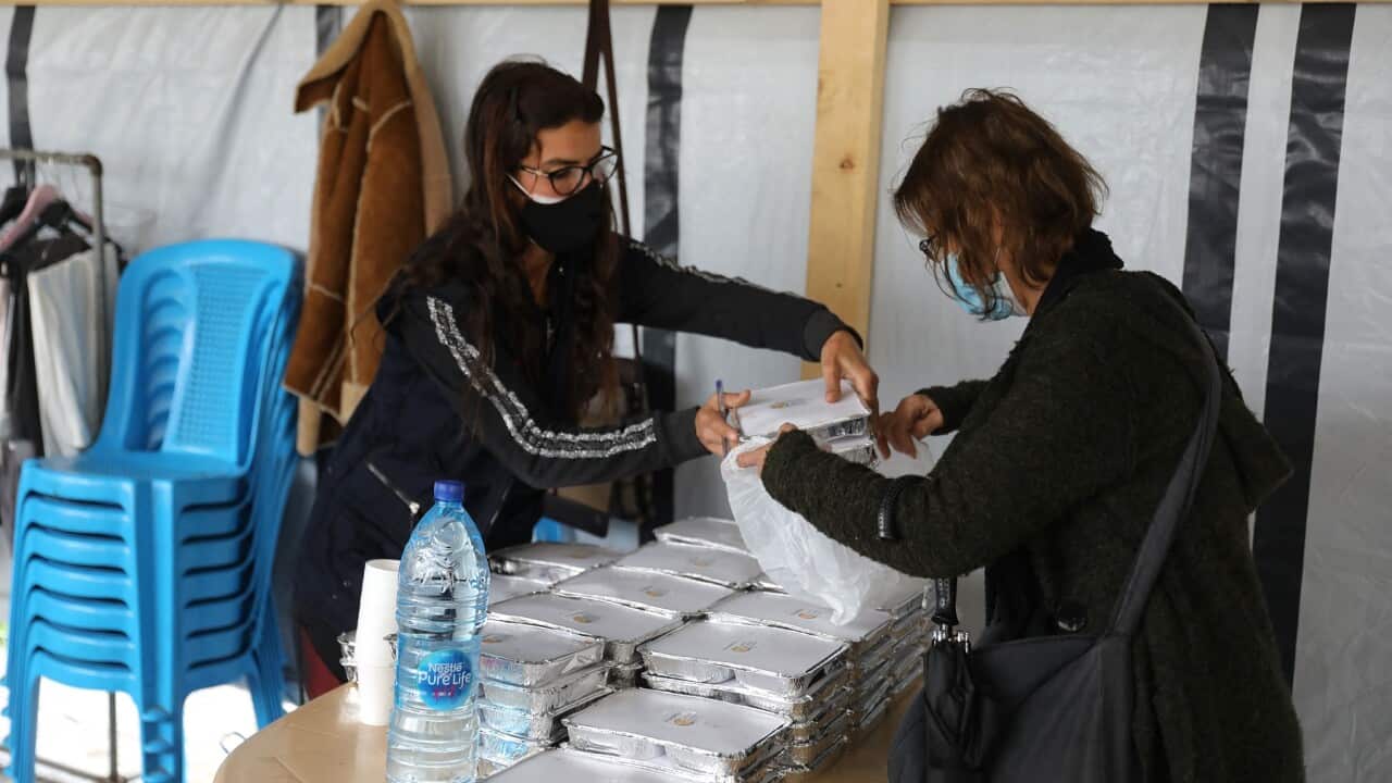 A volunteer gives food handouts to people in need in Beirut