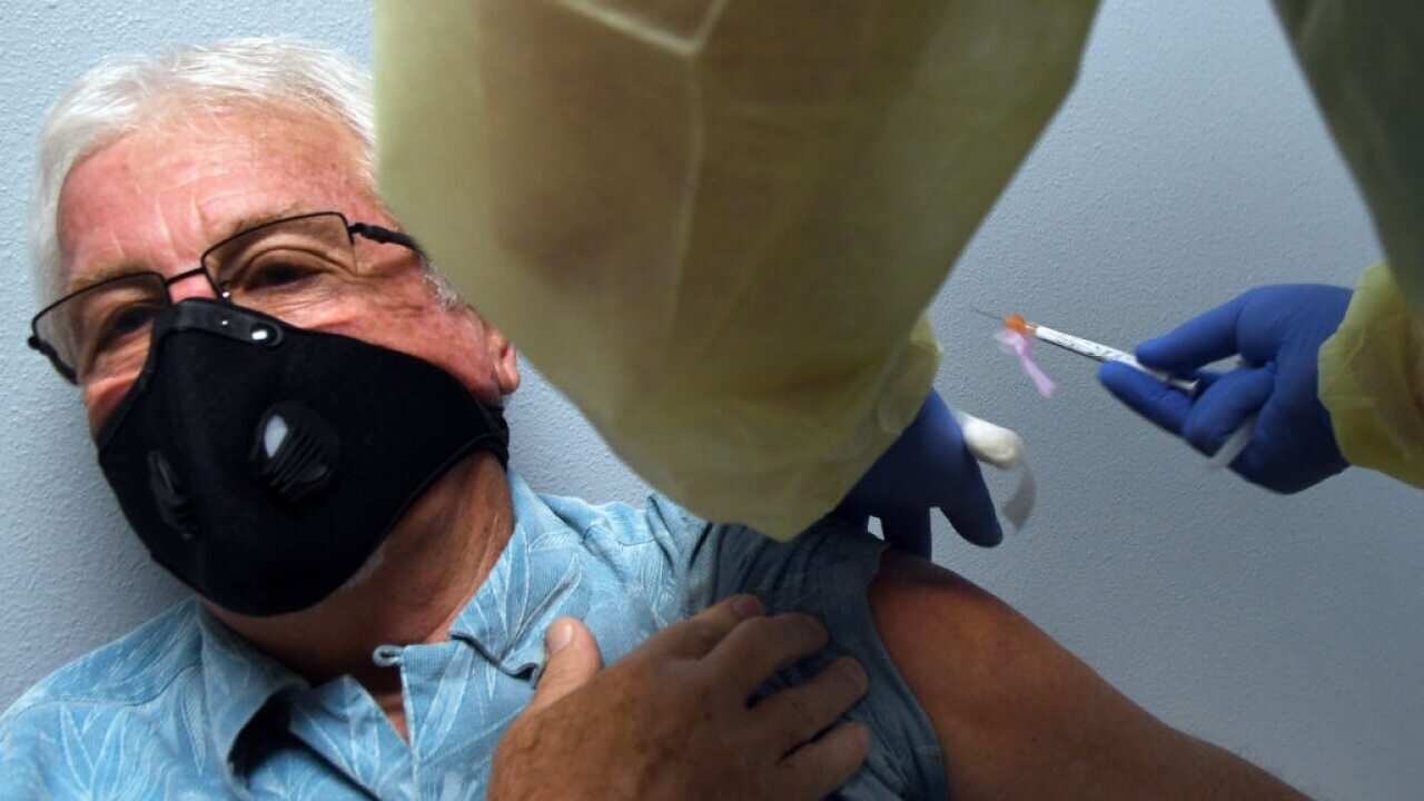 A man receives his first injection as a participant in a Phase 3 COVID-19 vaccine clinical trial for Moderna.