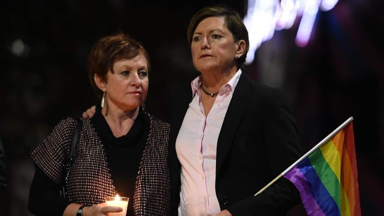 Christine Forster and partner Virginia Edwards attend a vigil.