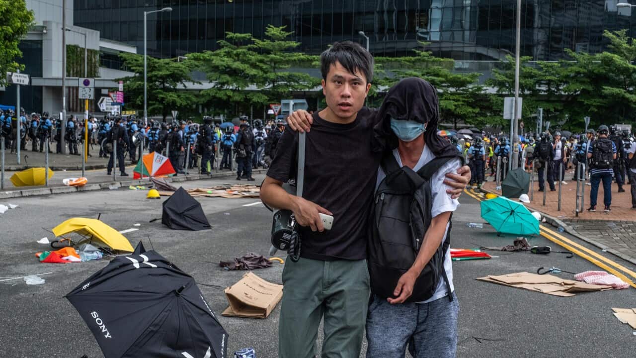 Roy Kwong, a politician, escorts a protester to an ambulance during early-morning clashes with the police in the Wan Chai district of Hong Kong, July 1, 2019. Kwong has emerged as a hero for the city’s youth and a leading voice for moderation during the p