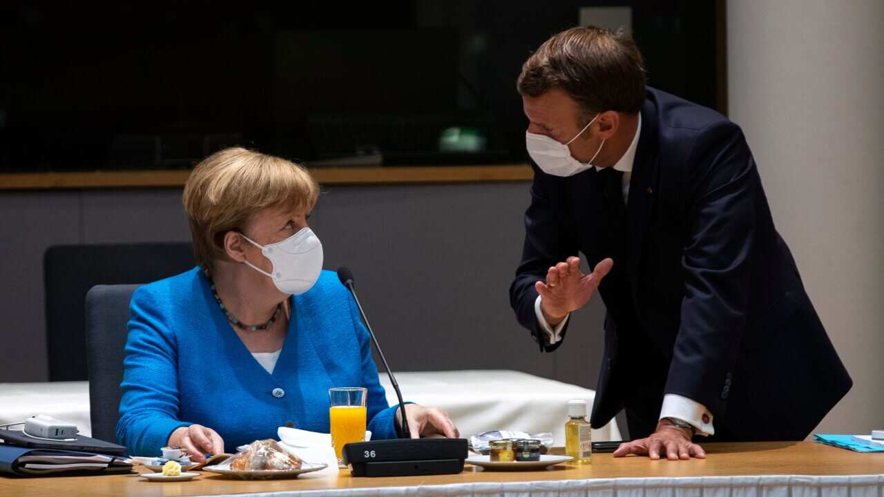 German Chancellor Angela Merkel speaks with French President Emmanuel Macron during a meeting on the sidelines of an EU summit in Brussels.
