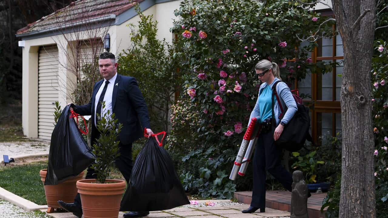 The AFP leave a home during a raid in Canberra