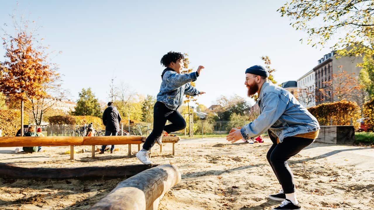 A young boy jumps into his father's arms
