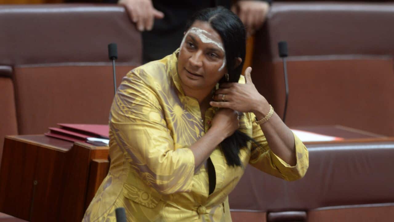 A Wednesday, Nov. 13, 2013 file image reissued Tuesday, May 24, 2016 of NT Senator Nova Peris braiding her hair before delivering her maiden speech to the Senate chamber at Parliament House in Canberra. Labor senator Nova Peris says she will not recontest