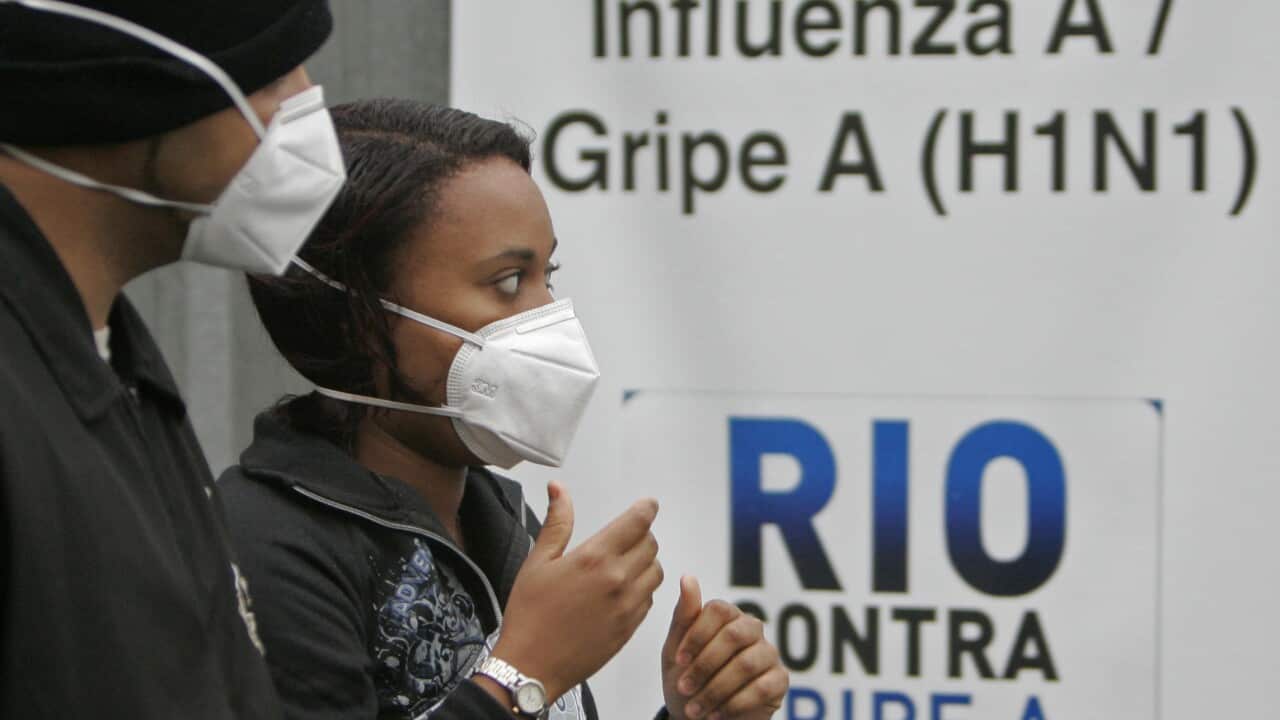 File photo from 2009: A woman and a man wearing masks to prevent infection from swine flu arrive at the Miguel Couto hospital in Rio de Janeiro.