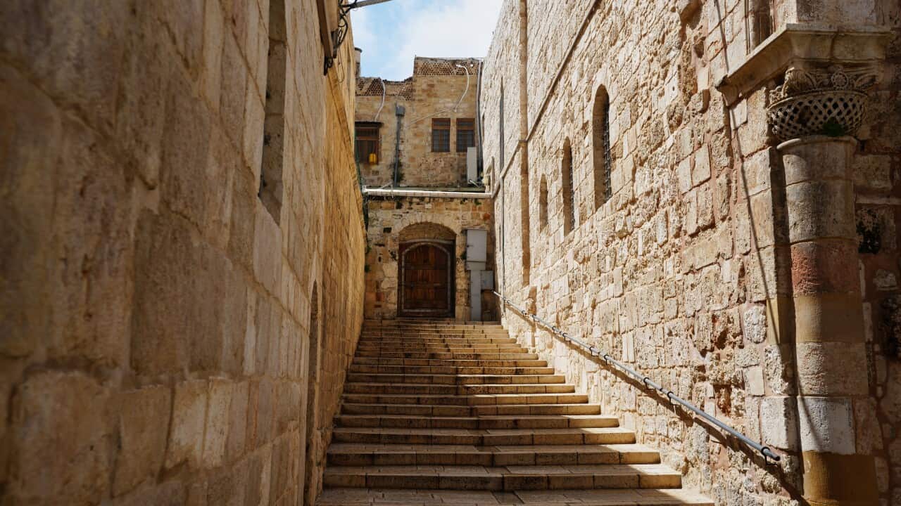 A locked door and empty stairs leading to a church