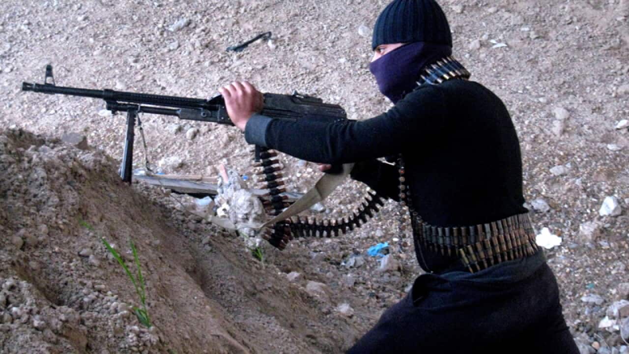 A gunman takes cover during clashes outside Fallujah