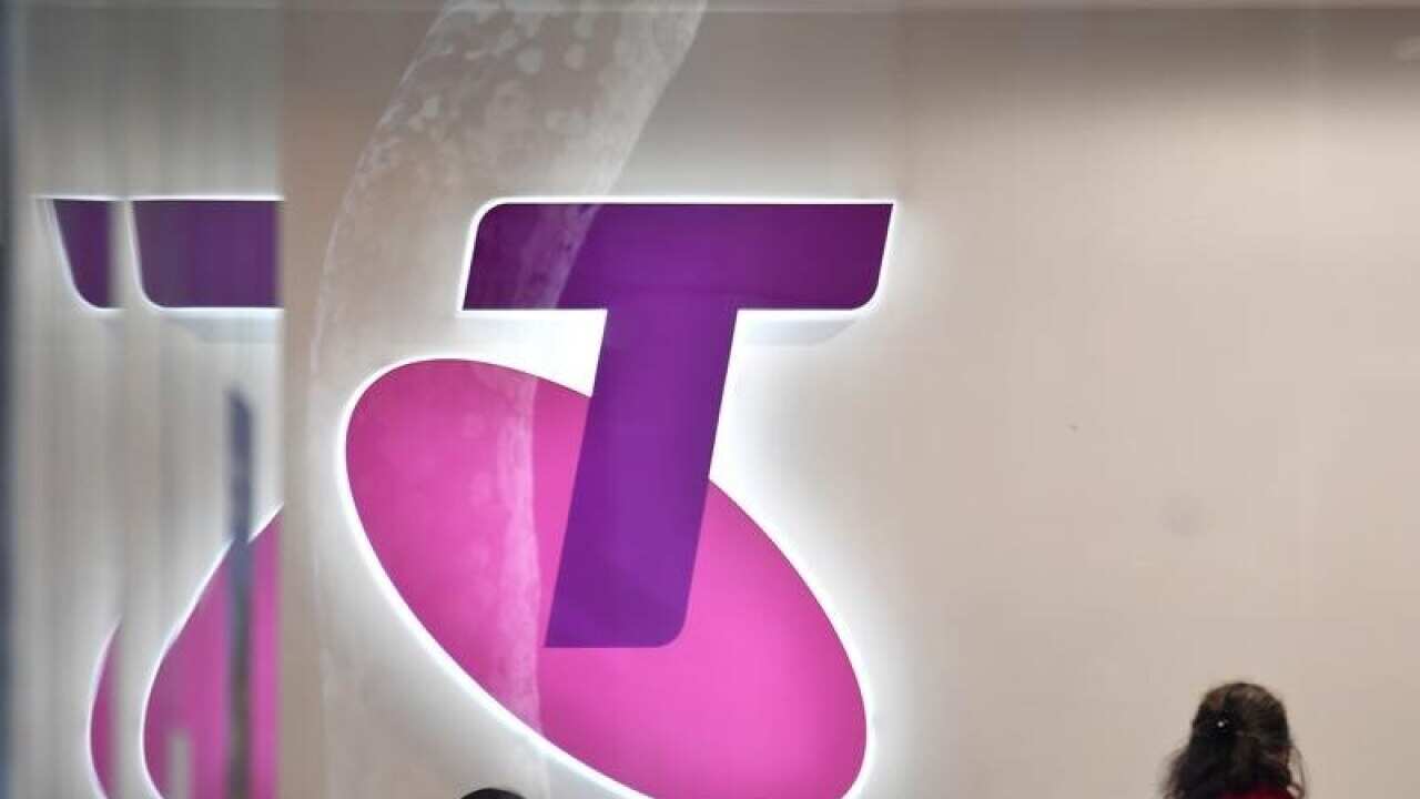 Customers and assistants are seen in a Telstra store in Sydney.