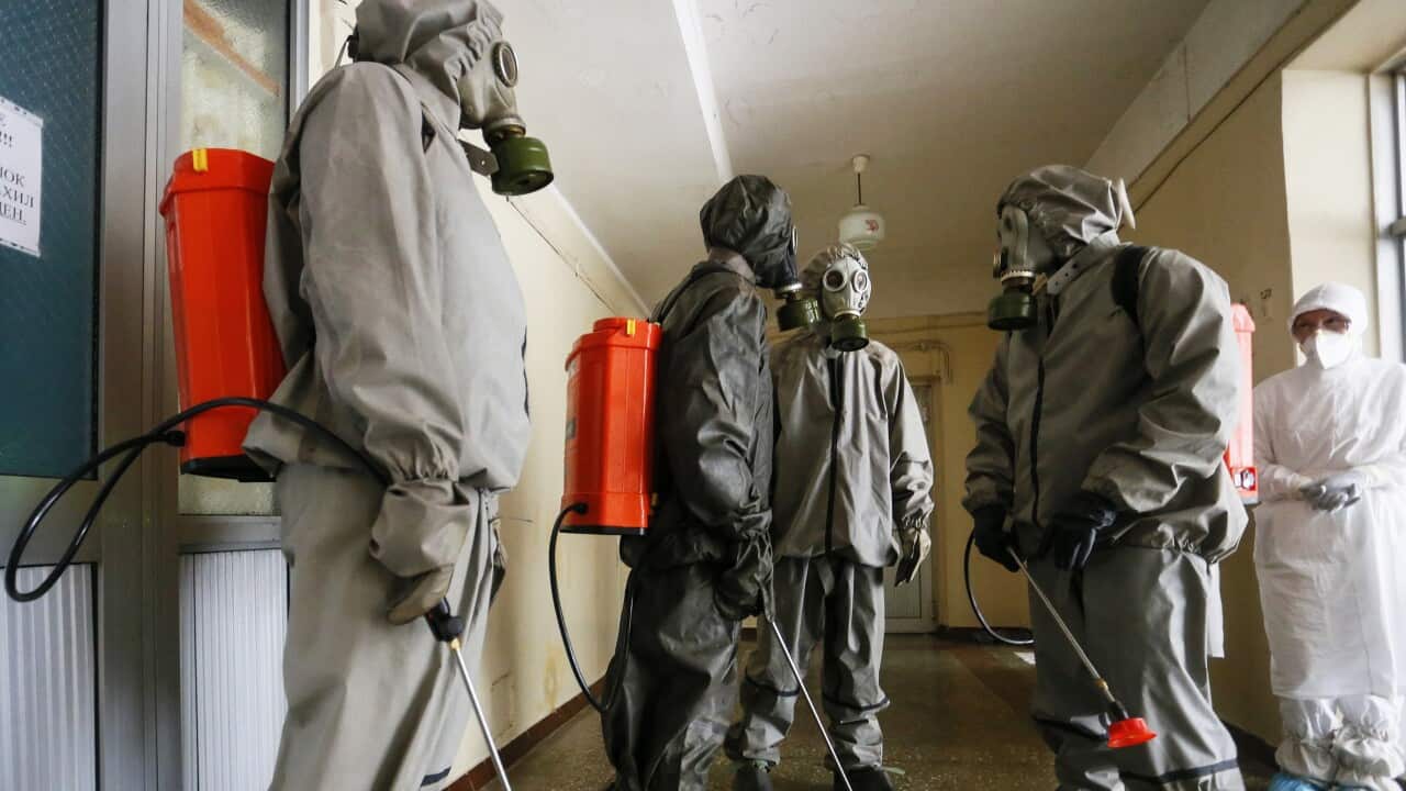 Workers of the Emergency Service of the Ministry of self-proclaimed Donetsk People's Republic (DPR) prepare to spray disinfectant inside a hospital.
