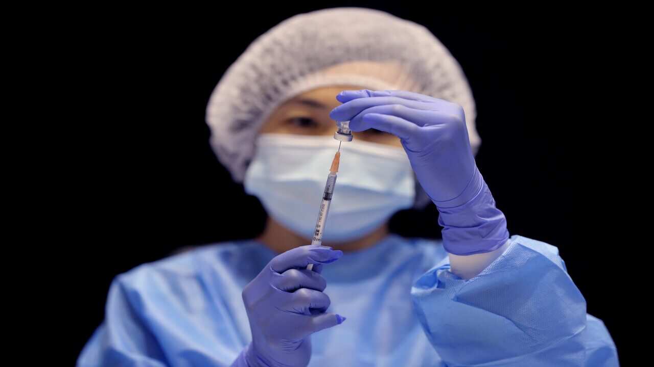 A healthcare worker fills a syringe with the Pfizer vaccine on the opening day of a COVID-19 mass vaccination clinic in Perth, 16 August, 2021.