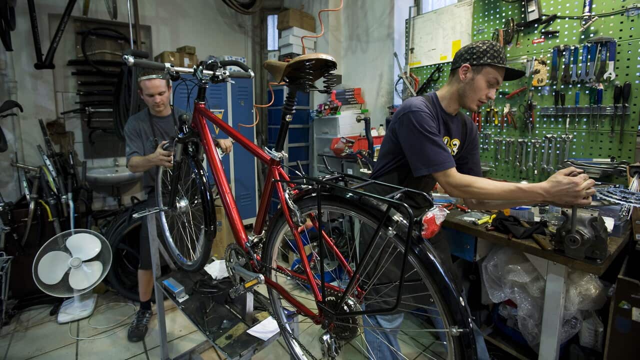 repairs bicycle tools wrenches fan fans red bike cycle cyclists man men work working mechanic mechanics tinker fix saddle handlebars seat wheel wheels spokes crossbar chain sprocket sprockets tools cycles mechanic workshop vehicle vehicles bicycles work