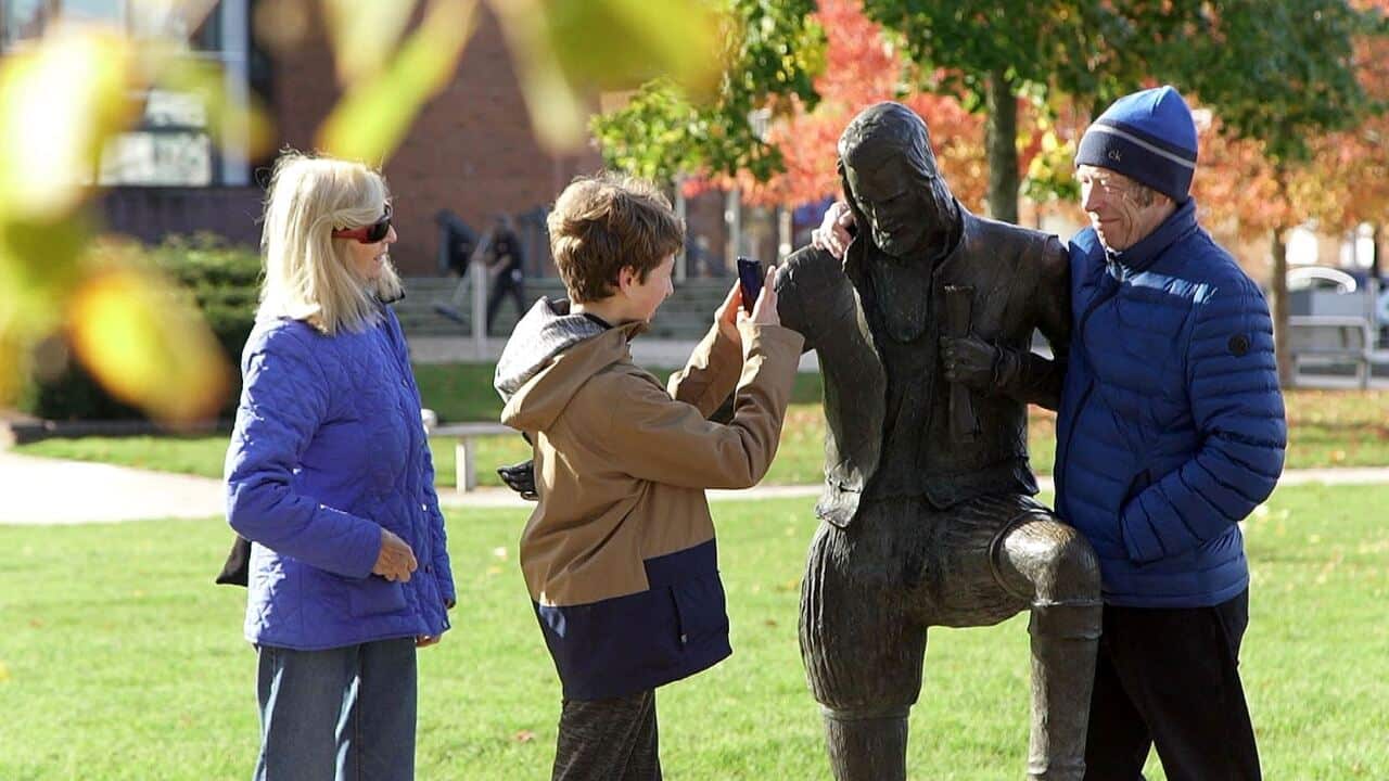 Tourists with a statue of Shakespeare in Stratford on Avon