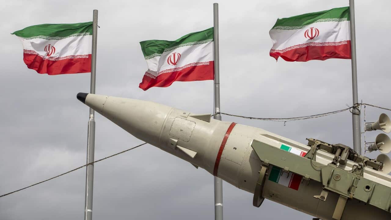 Missiles produced by Iran's armed forces are displayed near a row of Iranian flags (Getty)