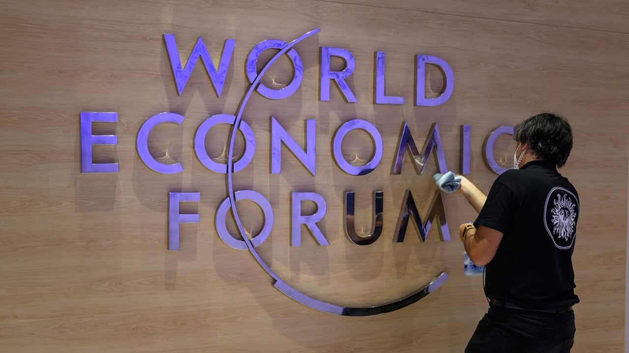 A worker cleans a sign of the logo of the World Economic Forum (WEF) inside the Congress centre ahead of the WEF annual meeting in Davos on May 22, 2022. (Photo by Fabrice COFFRINI / AFP) (Photo by FABRICE COFFRINI/AFP via Getty Images)