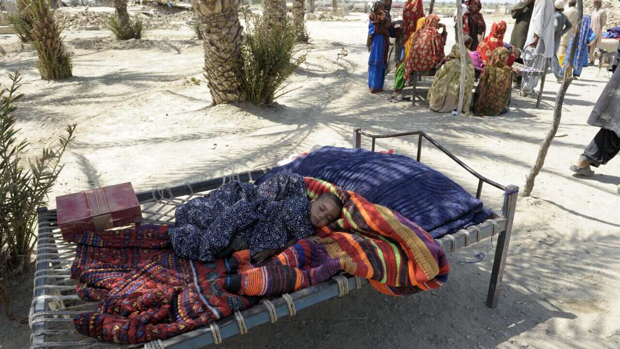 A Pakistani child sleeps as earthquake survivors gather near their collapsed mud houses in the earthquake-devastated district of Awaran AAP.jpg