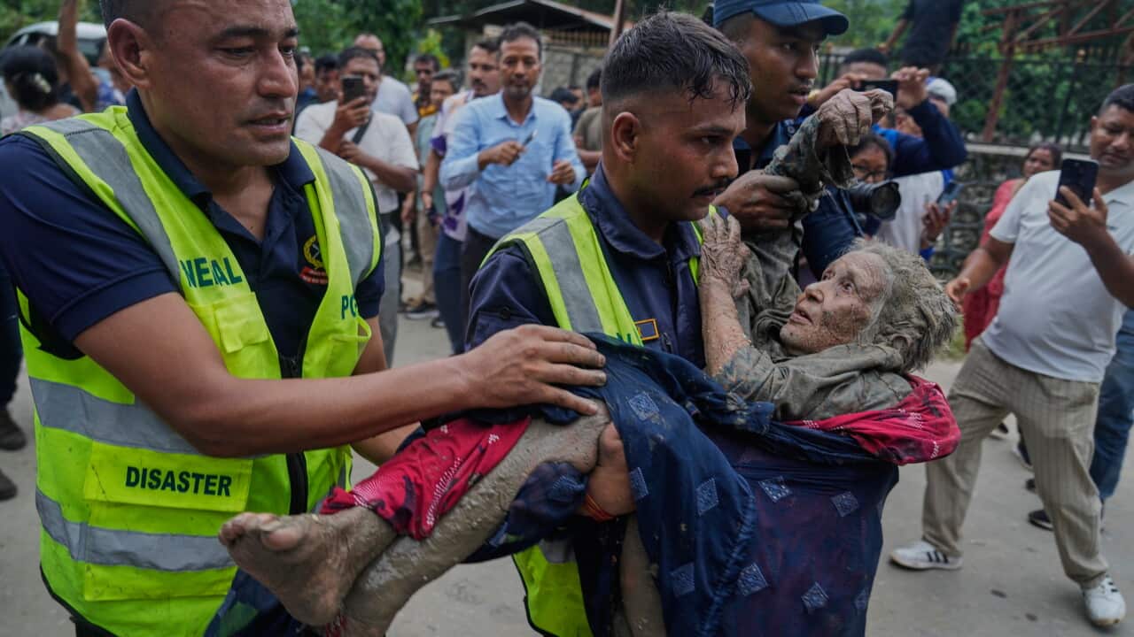 Rescuers carry a victim to safety in Nepal