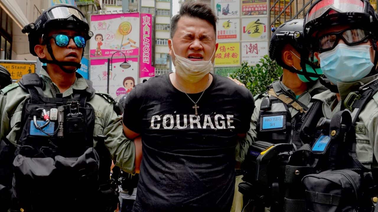 Police detain a protester after being pepper sprayed during a protest in Causeway Bay in Hong Kong on 1 July 2020.