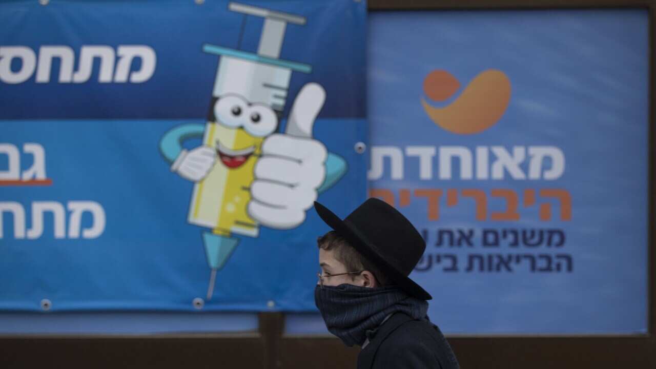 A young man walks past a coronavirus vaccination centre in Jerusalem, Wednesday, Dec. 22, 2021.