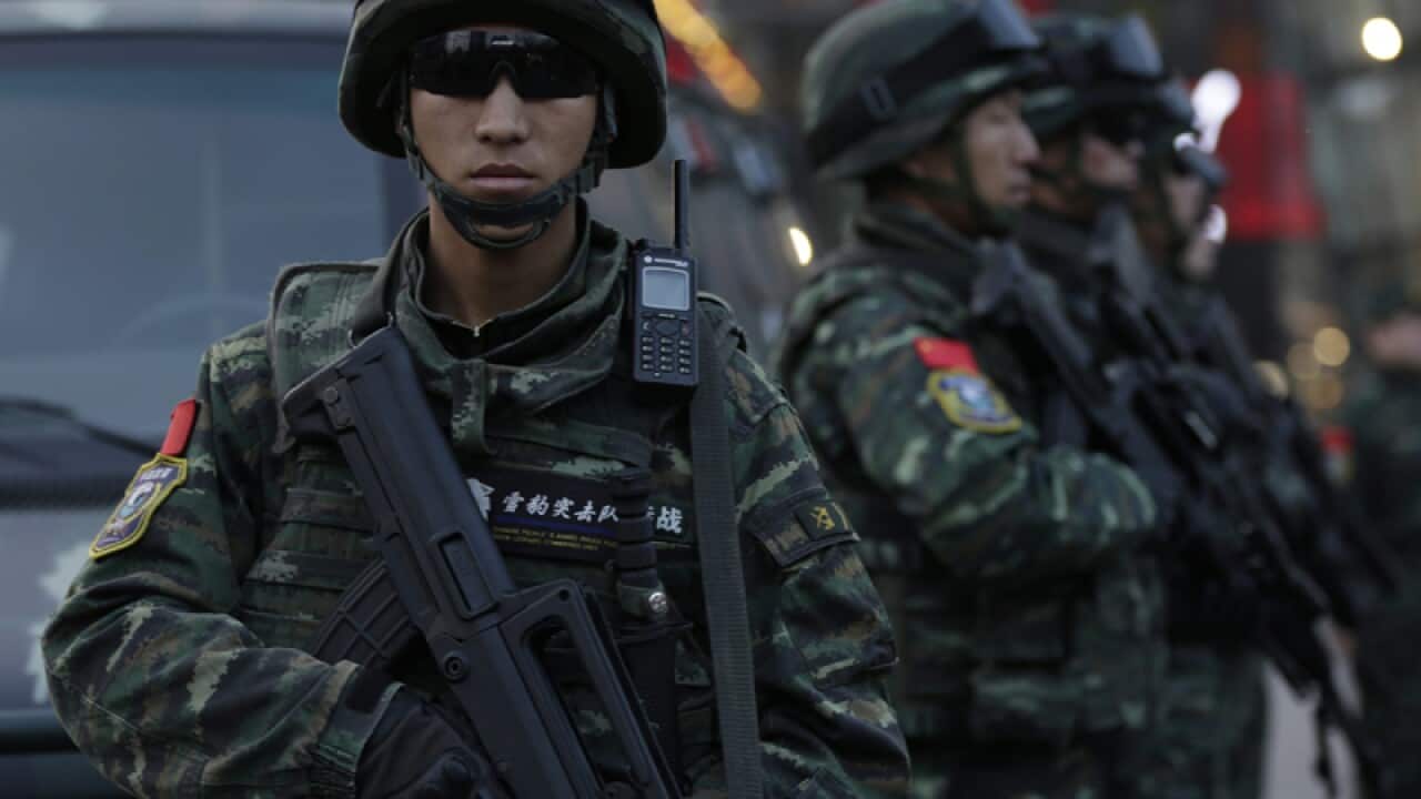 Chinese paramilitary police stand guard outside a shopping mall
