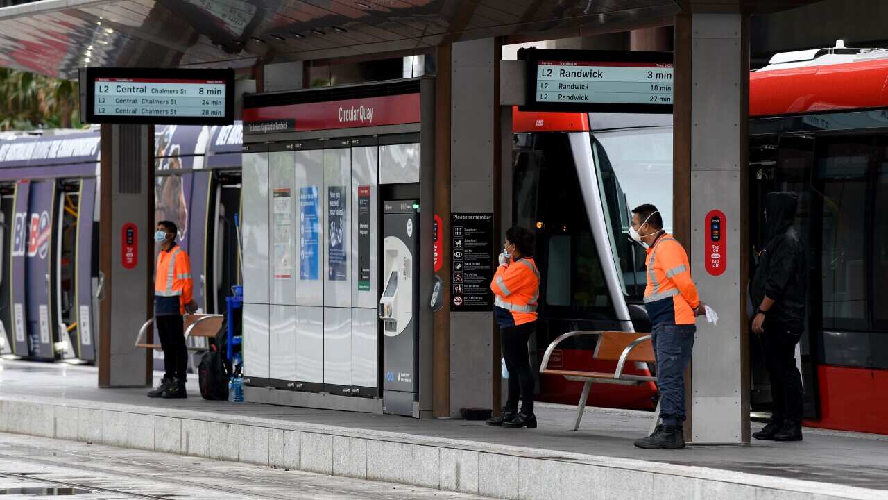 Cleaners are seen at the Circular Quay light rail station in Sydney