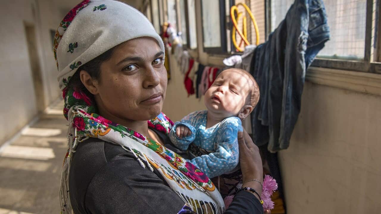 A displaced Syrian woman tends to a baby in the northeastern town of Hasakeh.