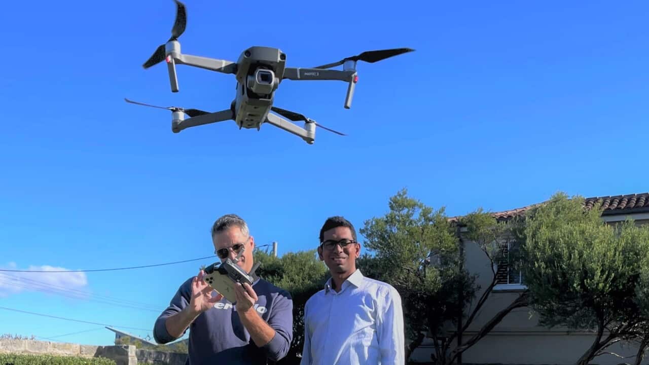 Tom Caska and Rakesh Routhu with one of their drones (SBS)