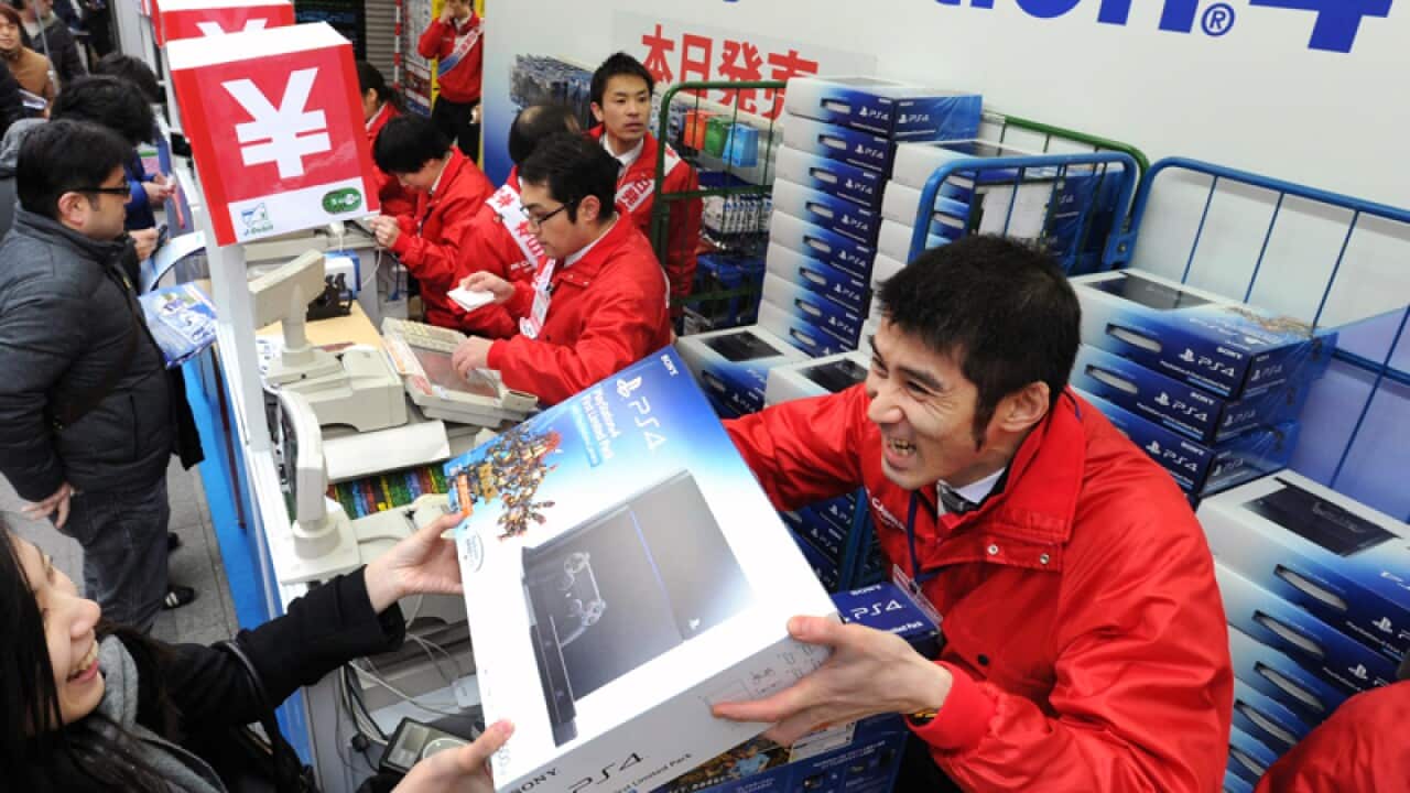 Customers buy PlayStation 4 consoles in Tokyo
