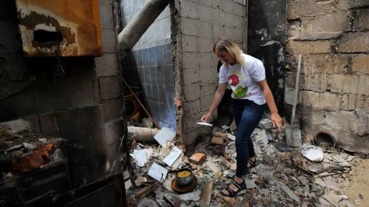 Irina, 35, cooks cottage cheese in the survived wood stove of her ruined house in the village of Novoselivka, outside Chernigiv in Ukraine
