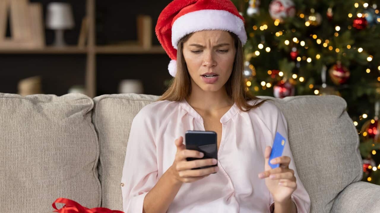 Worried concerned girl in Christmas Santa hat having problems