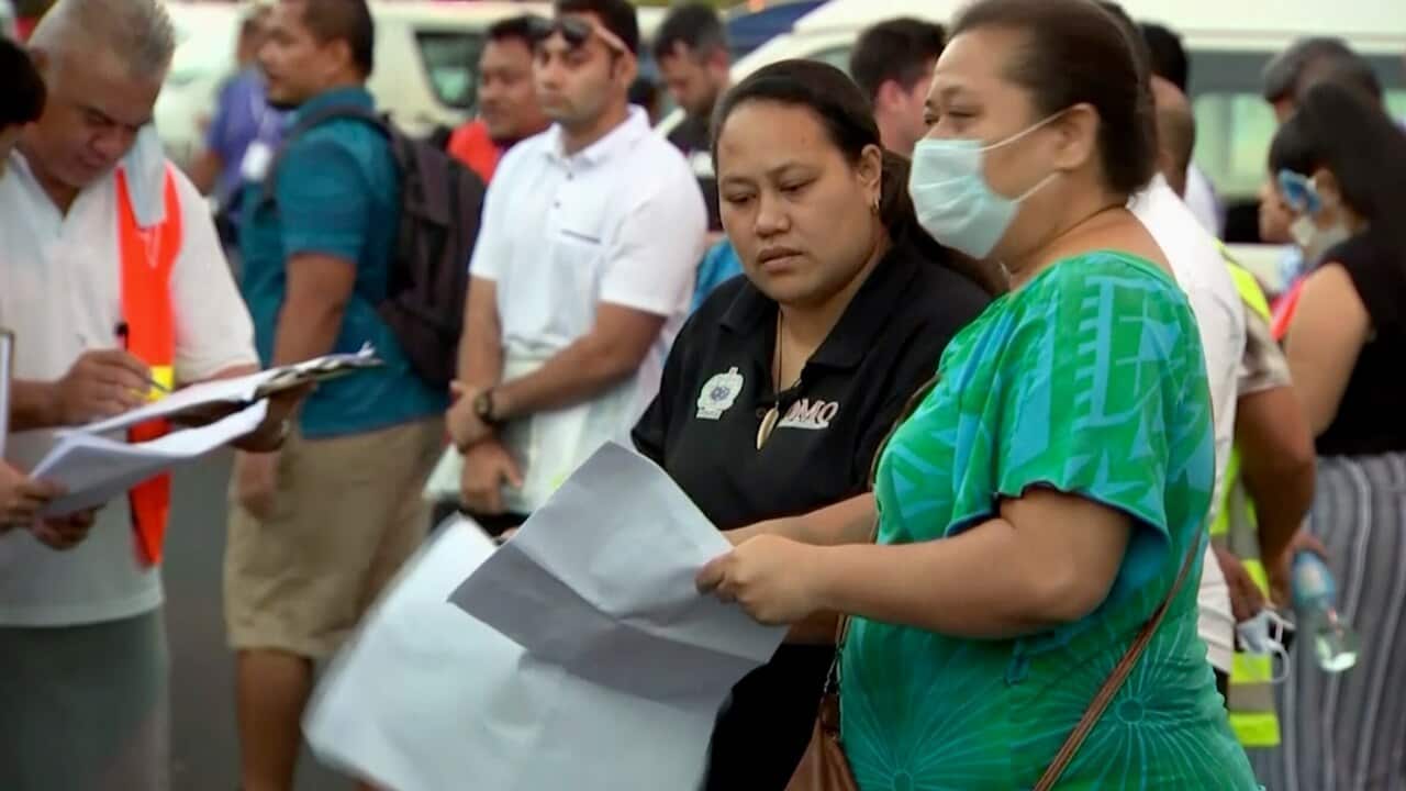 People gather outside a health emergency operation center Thursday, Dec. 5, 2019, in Apia, Samoa.