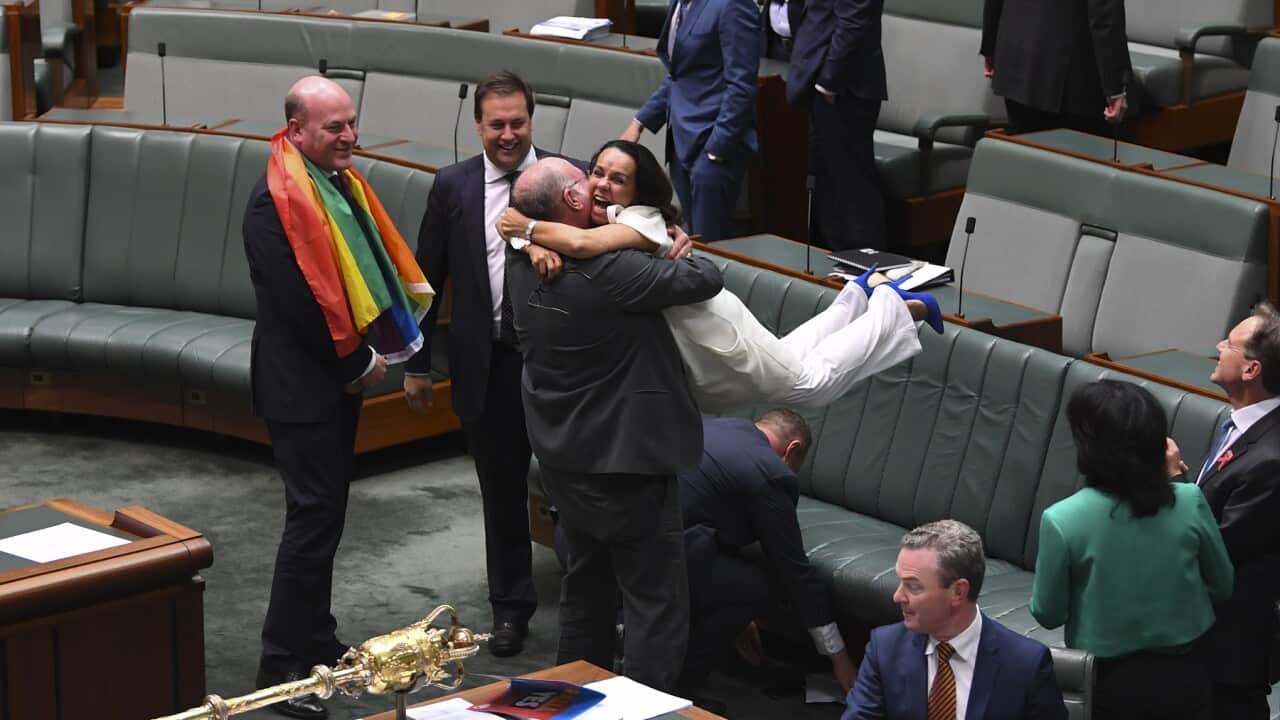 Liberal MP Warren Entsch lifts up Labor MP Linda Burney as they celebrate the passing of the Marriage Amendment Bill in the House of Representatives at Parliament House in Canberra, Thursday, December 7, 2017. (AAP Image/Lukas Coch) NO ARCHIVING