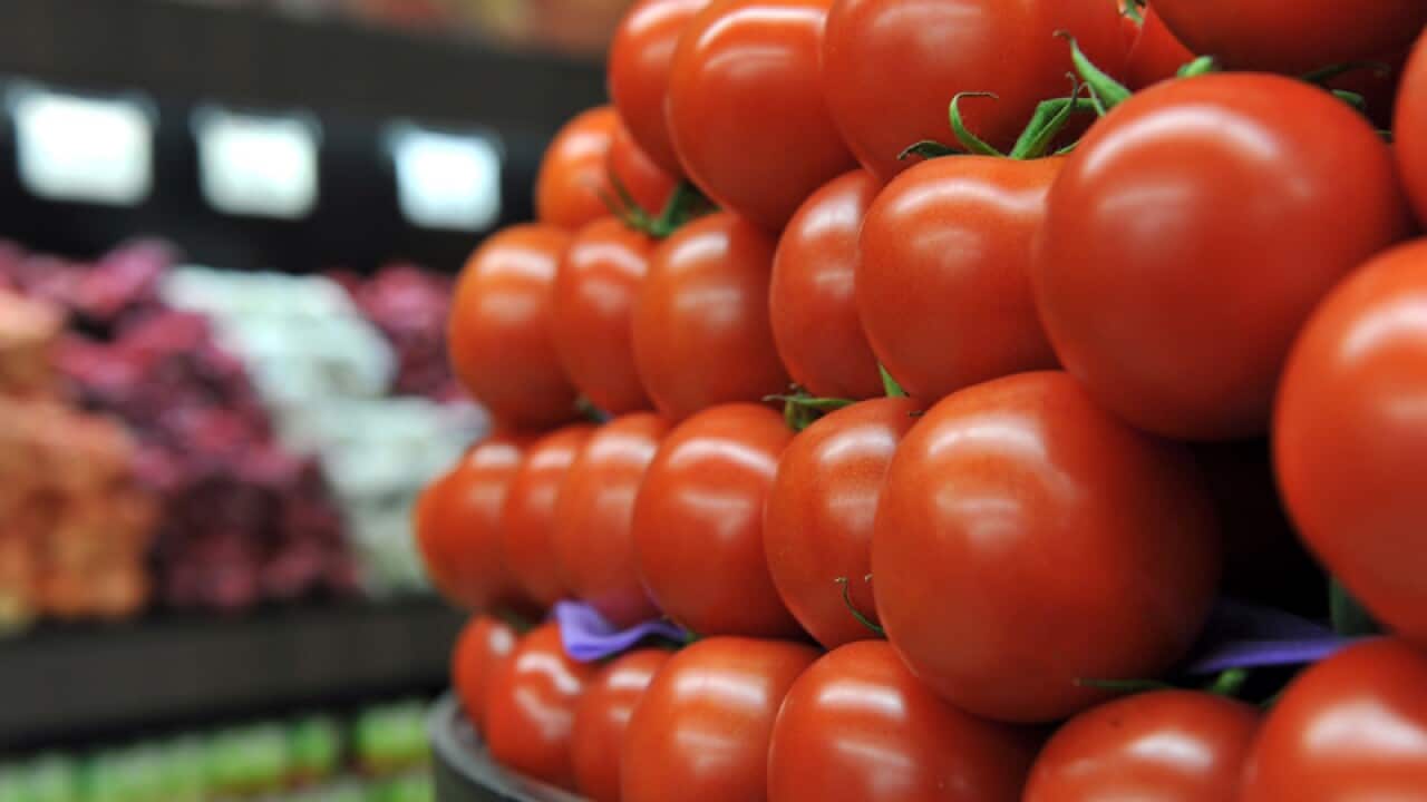 Truss tomatoes sit on a stall at a fruit store