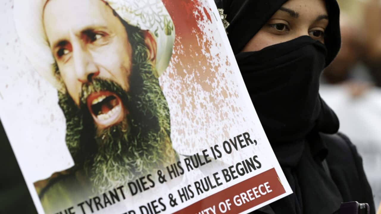 A Shia Muslim with a picture of cleric Nimr al-Nimr